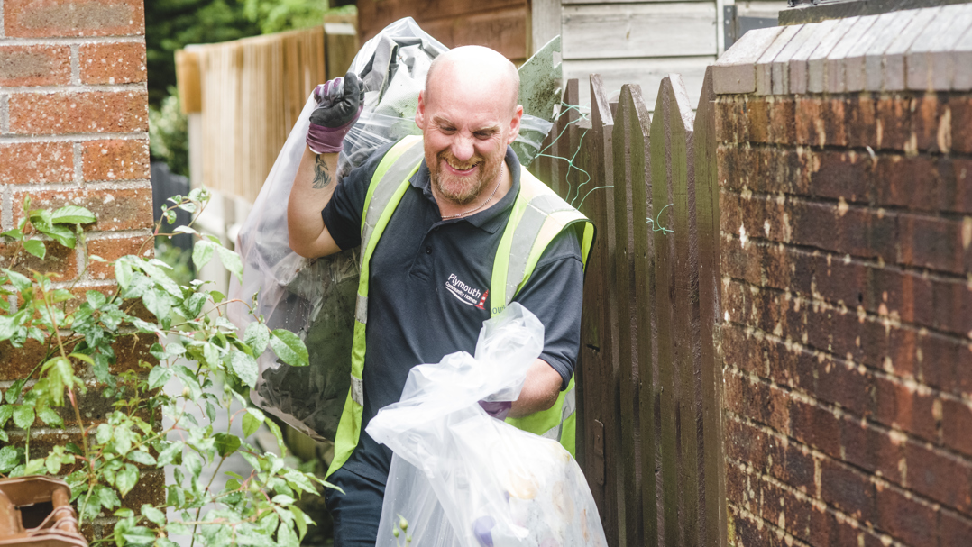 Staff member picking up rubbish bags