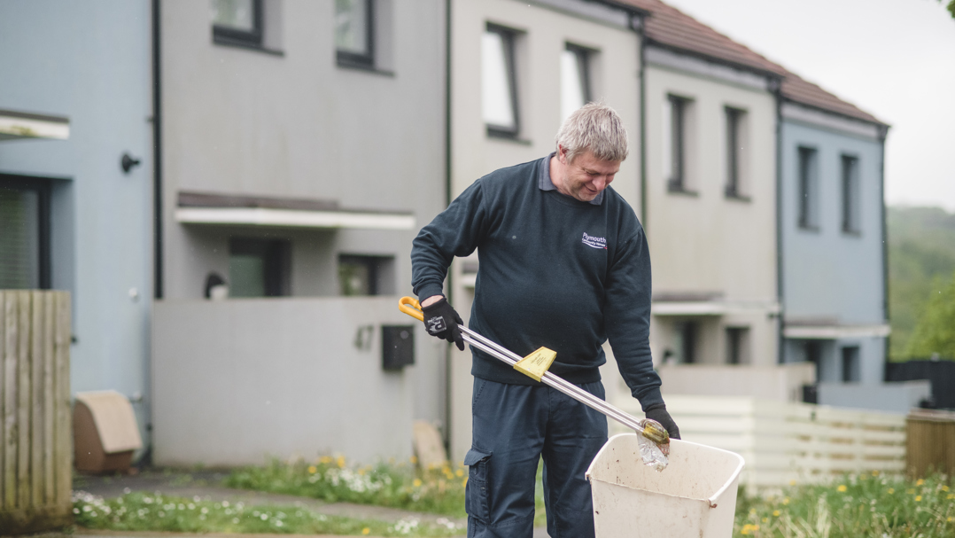 Member of staff picking up rubbish