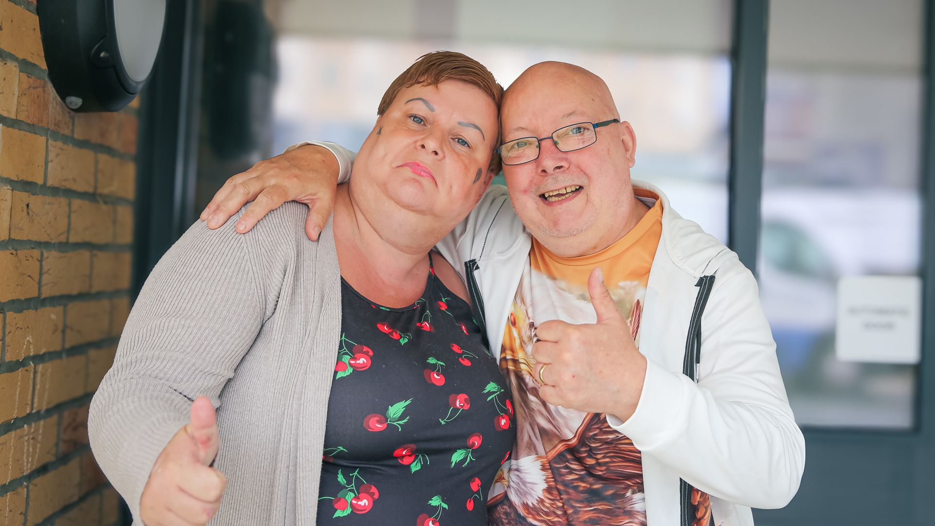 Residents smiling at camera with thumbs up