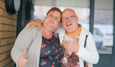 Residents smiling at camera with thumbs up